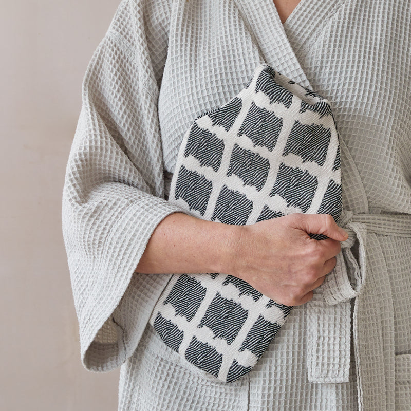 Beatrice Larkin weaved merino wool hot water bottle in Ikat black and cream pattern.