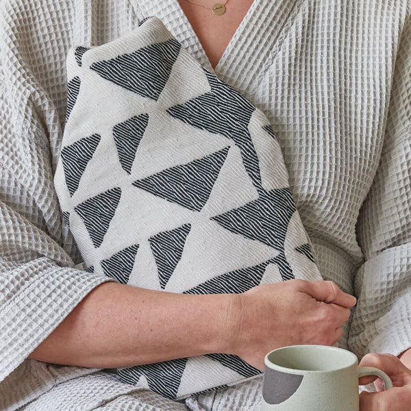 soft merino wool hot water bottle by British Maker Beatrice Larkin, black and white abstract pattern.