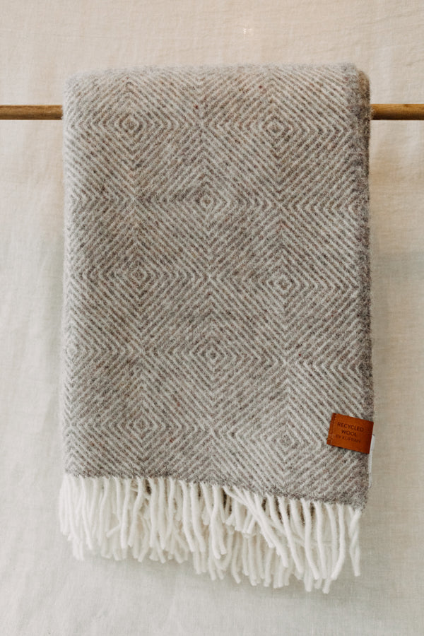 Grey colour diamond weave blanket in a recycled wool and lambswool mix with tassel trim