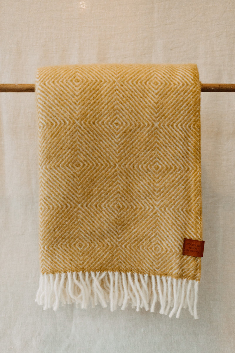 Mustard colour diamond weave blanket in a recycled wool and lambswool mix with tassel trim