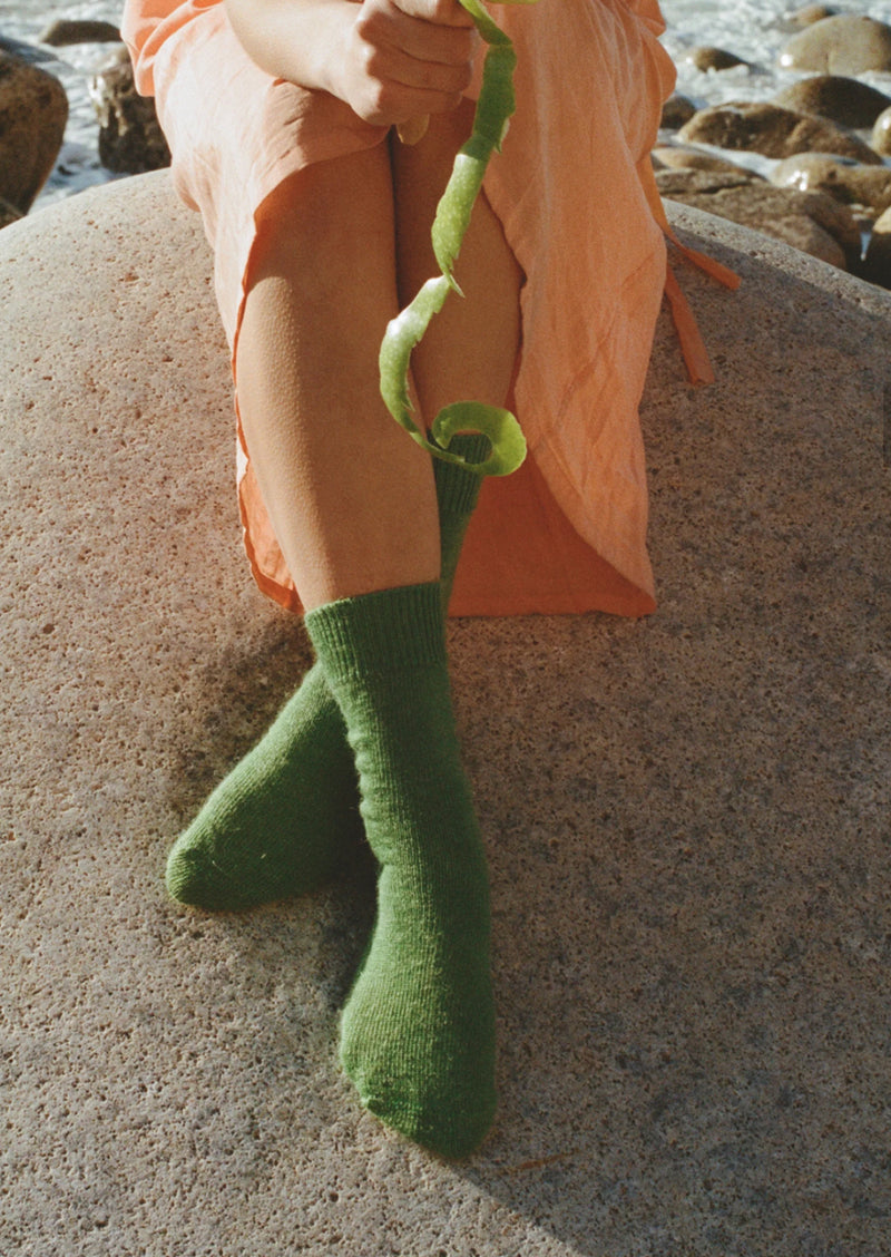 styled shoot beach image of feet wearing verdigris green mohair Oaken socks available at Ash, Falmouth