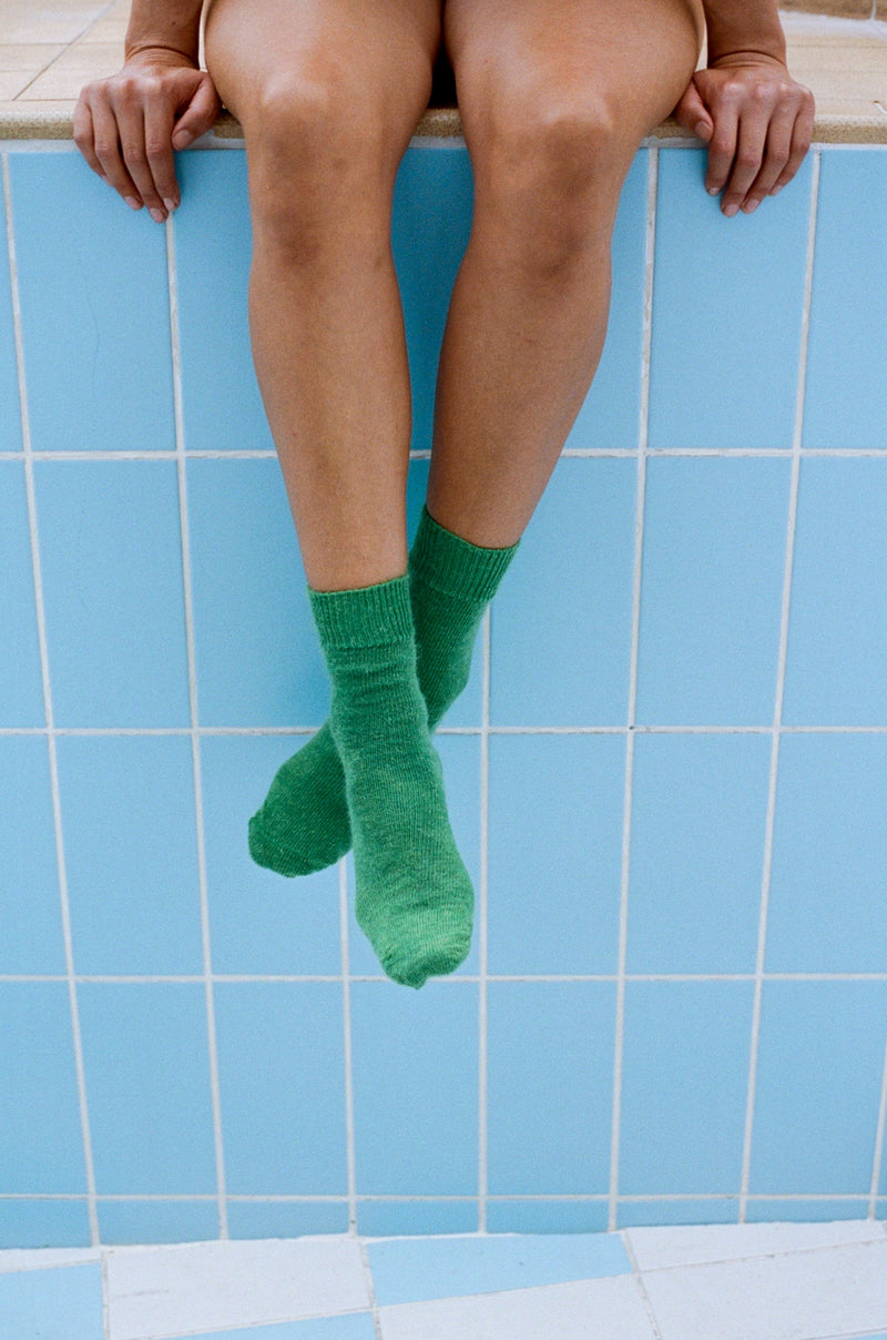 styled shoot tiled pool image of feet wearing verdigris green mohair Oaken socks available at Ash, Falmouth