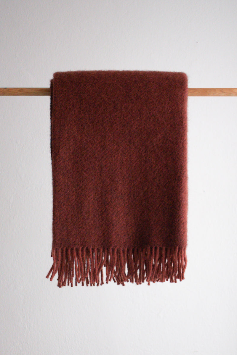 Rust colour lambswool and recycled wool blanket with tassel detail