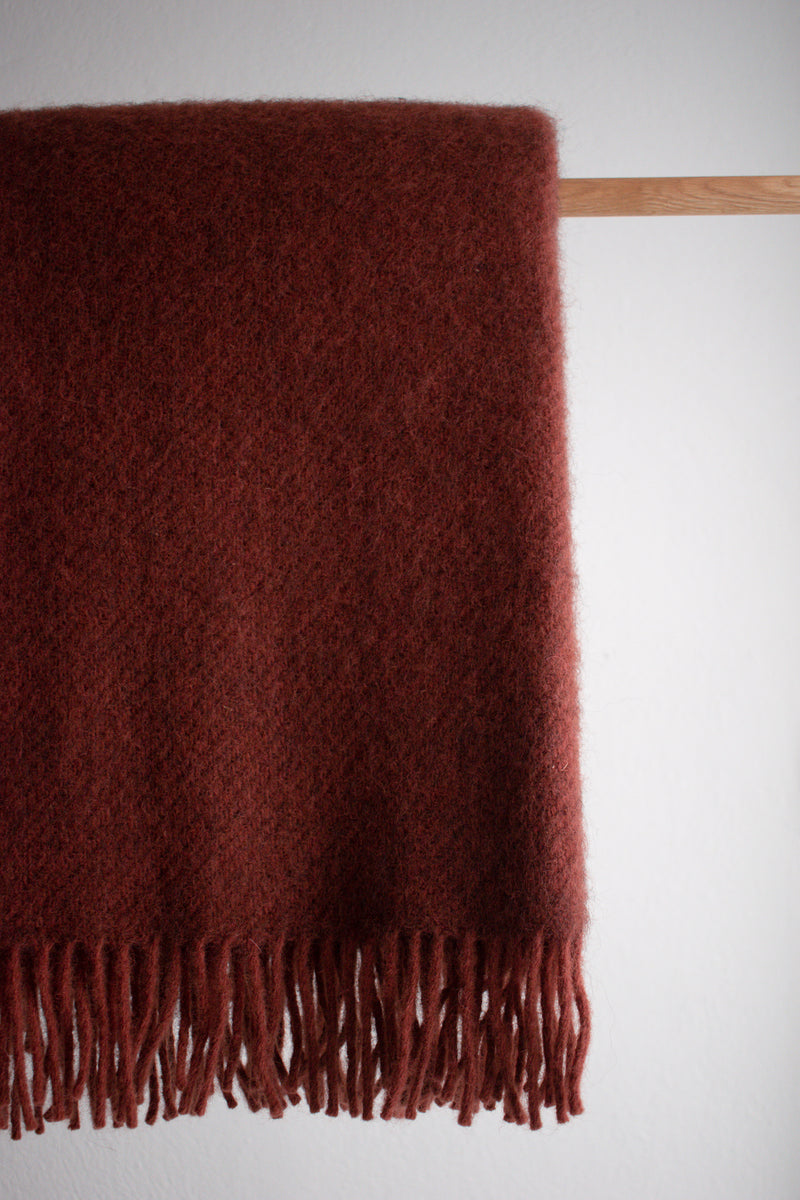 Rust colour lambswool and recycled wool blanket with tassel detail