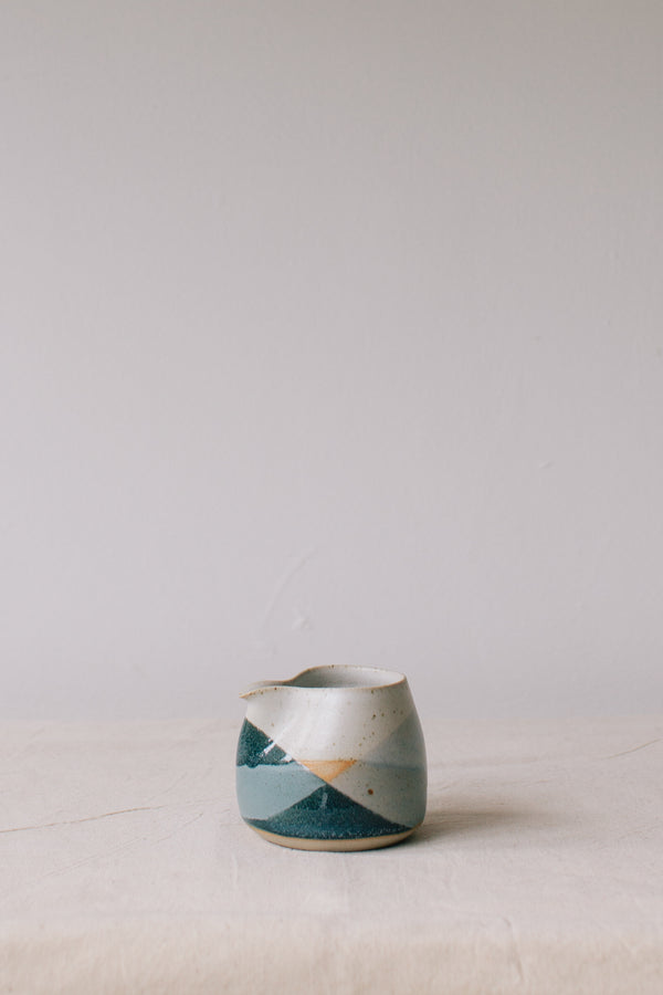 Handmade ceramic jug by Liz Vidal. Liz uses different tones of blue glaze to dip her jugs to create an abstract landscape design.