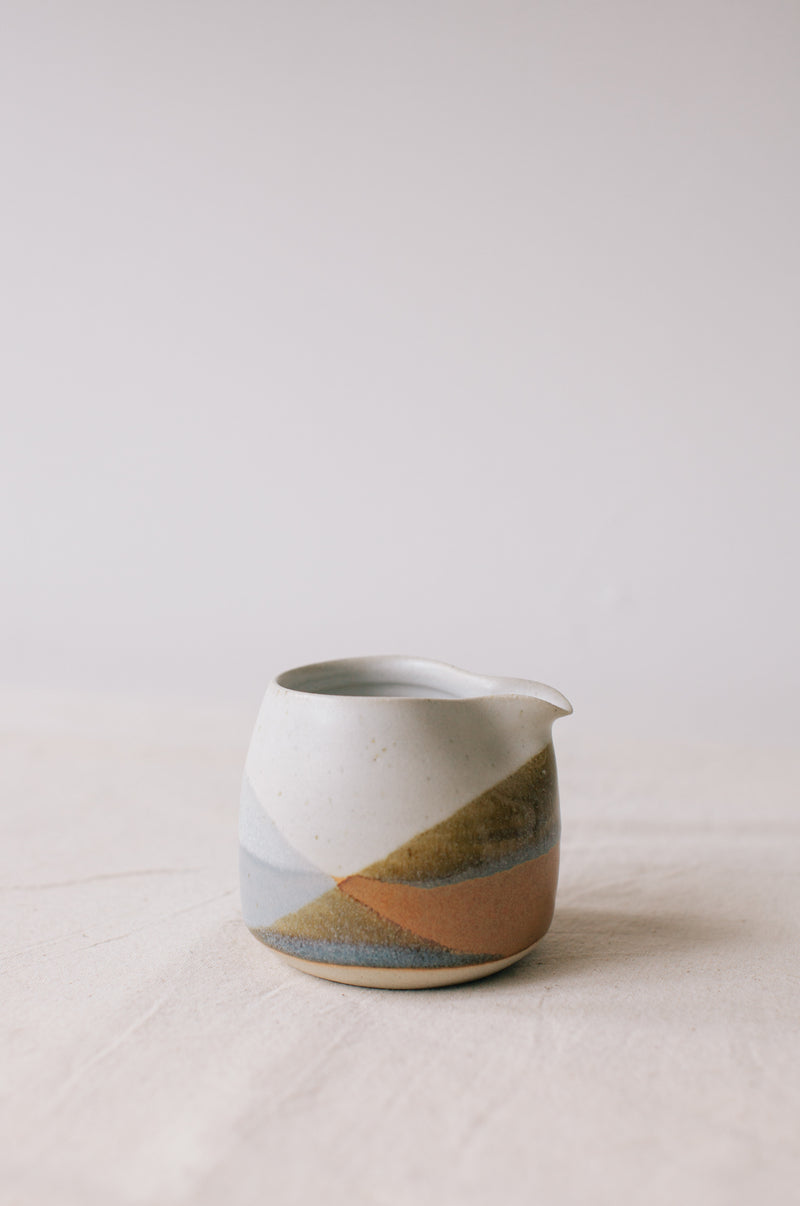 Handmade ceramic jug by Liz Vidal. Liz uses different tones of rust and brown glaze to dip her jugs to create an abstract landscape design.